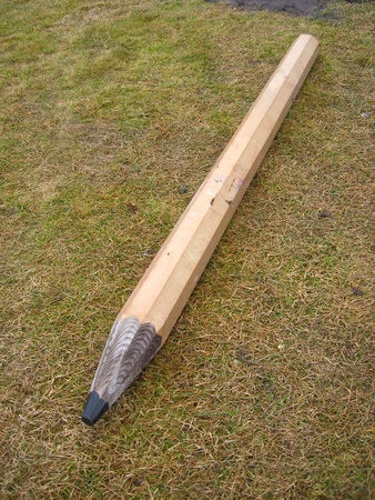 Huge artificial pencil laying on the groundの写真素材