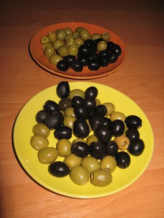 two plates of black and green olivesの写真素材
