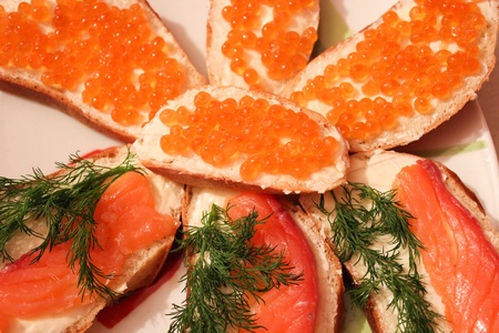 a lot of sandwiches with red caviar and red fishの写真素材