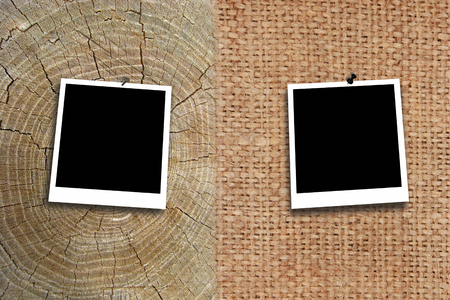 two empty photos stuck by pin to the texture of sacking and wooden