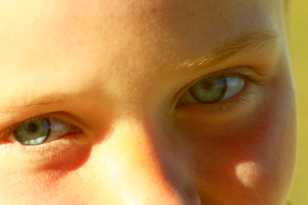 little girl's blue eyes staring up and smilingの写真素材