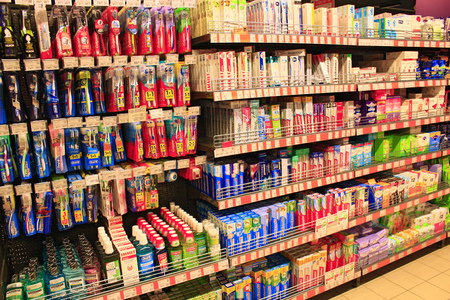 different kinds of toothpaste and brushes and other hygiene products with wide assortment on the shelves of supermarketのeditorial素材