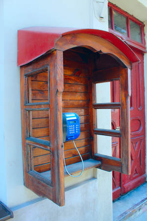 opened cabin with blue street pay phoneの写真素材