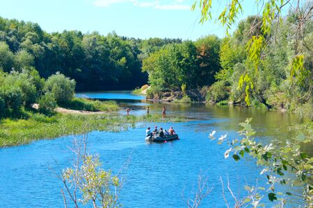 beautiful landscape with river and canoe with people on itのeditorial素材