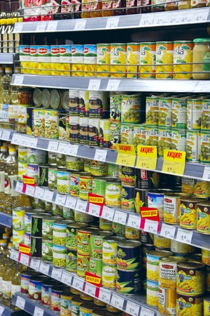 Store canned in shop. Canned food on supermarket shelves pineapples, green peas, olivesのeditorial素材