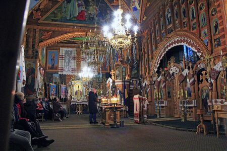 Beautiful interior and decoration in Orthodox church. People praying inside of church during service.のeditorial素材