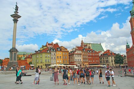 People stroll through krakowskie przedmiescie street in Warsaw, Poland. Tourists walk around old...
