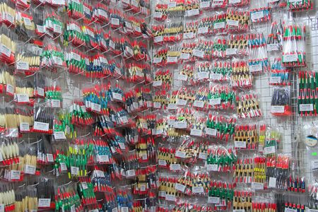 Colorful fishing floats on sale in supermarket. Fishing bobs are sold in store. Wide assortment of fishing floats in fishing shop. Fish floatss in shopのeditorial素材