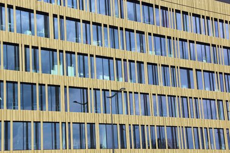 Skyscraper in Lodz. Tall skyscraper with blue windows in Lodz. Modern building with equal windows standing in Polish city Lodz. Street wall background. Industrial pattern in cityのeditorial素材