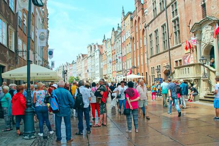 Tourists stroll on Gdansk during rain. Many tourists walk around Gdansk. Beautiful tourist Polish city of Gdansk. Group of Europian tourists during journeyのeditorial素材