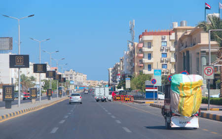 City panorama with street cars about buildings in Hurghada. Modern city with cars on highway. Transportation and traffic on highway in Hurghada city. Busy street in Egyptian city Hurghadaのeditorial素材
