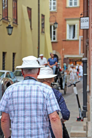 White-headed tourists in hats travel around city. People of retirement age walk around city while walking. Old people going around the cityのeditorial素材