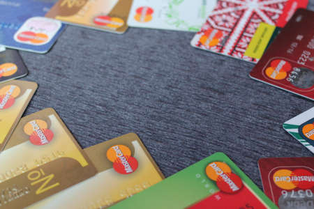 Credit cards of Mastercard lie around perimeter of the frame on dark background. Credit cards and place for text. Copyspace with Mastercard credit cardsのeditorial素材