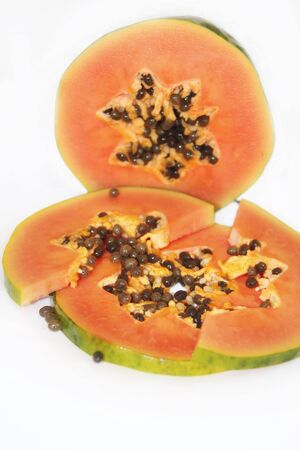 papaya fruit with seeds. Cut papaya slice on white background. Ripe sweet papaya fruitsの写真素材