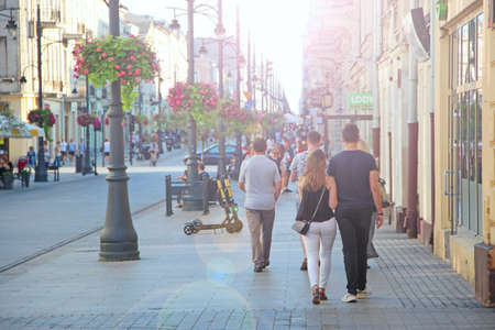 Central street of Lodz decorated with Polish flags. People walking along city street. View of main street of Lodz. Central street of Lodz Piotrkowska in the afternoonのeditorial素材