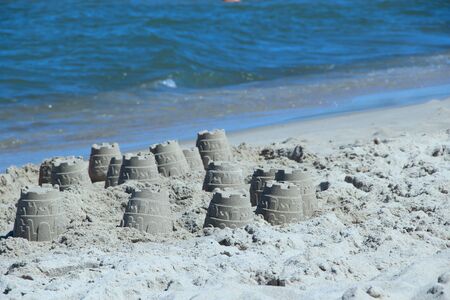 Sandy pyramid on the seashore. Sand pyramid built on the seaside. Childish works. Sand houses built...