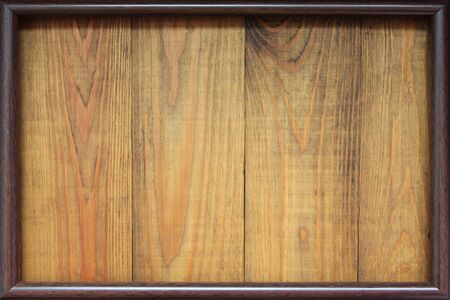 Brown frame on wooden background. Dark frame on wooden texture. Old grunge dark texture. Frame for...