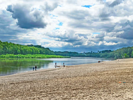 Empty beach near the river during the coronavirus pandemic. Beautiful summer landscape with sandy beach during Coronavirus. White clouds above empty city beachの写真素材