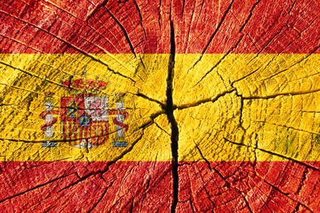 Spainish national flag printed on wooden cracked surface. National flag of Spain. Wooden texture with Spanish flag. Spainish symbolの写真素材