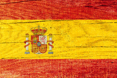 Spainish national flag printed on wooden cracked surface. National flag of Spain. Wooden texture with Spanish flag. Spainish symbolの写真素材