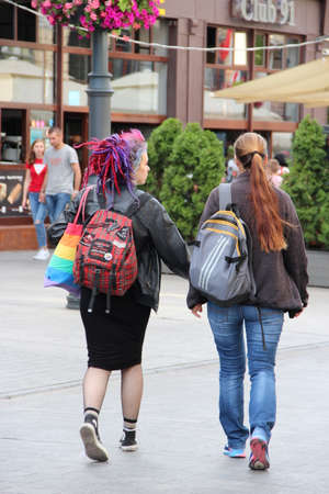 Two modern girls with multi-colored Dreadlocks hair walking down the street. Girls enjoy walk after coronavirus quarantine. Two girlfriends walking around the city. Informal youthのeditorial素材