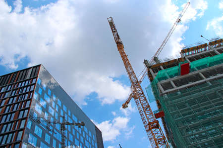 Crane working on construction site. Industrial crane working on construction of skyscraper....