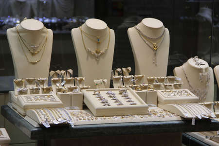Jewelry is presented on shop window of chain, rings, bracelets, pendants, watches. Variety of jewelry in window of jewelry store. Shop of gold and silver productsのeditorial素材