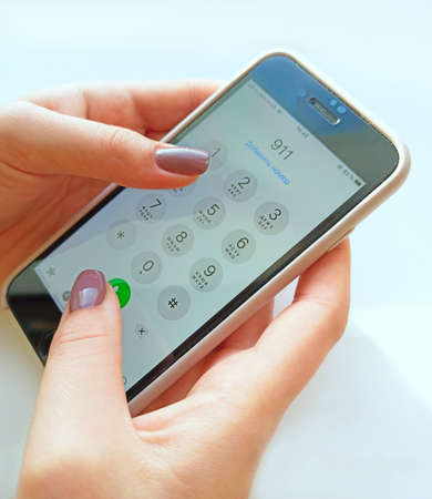 mobile phone in human hand. Human hand pushing buttons on modern smartphone. Screen in hand. Female...