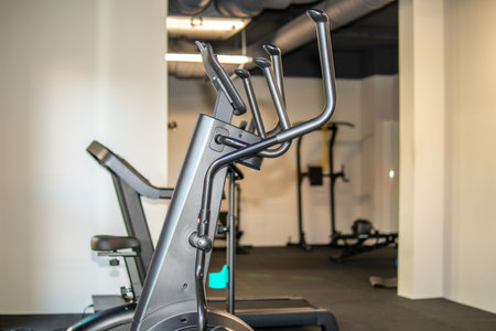 Elliptical trainer in modern gym interior, empty fitness room with cardio equipment, healthy...
