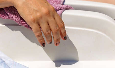 Female hand hanging from couchesの写真素材