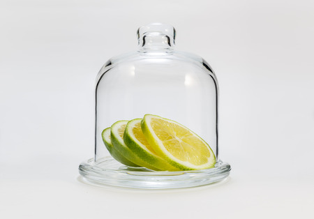 slices  green lemon  in a glass flask on a white backgroundの写真素材
