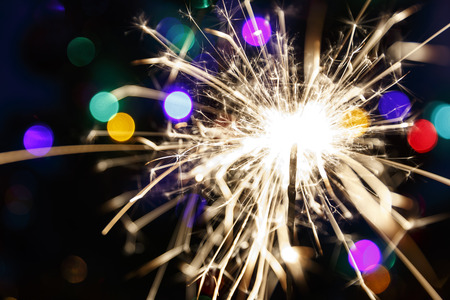 Lighted sparkler on a background garlands(soft focus)