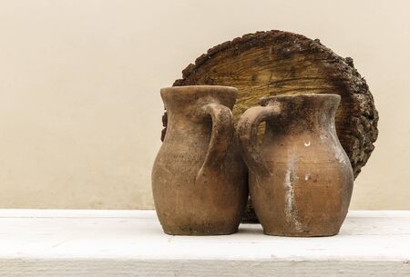 Old clay pot and a piece of woodの写真素材