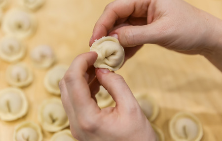 Female hands mold dumplingsの写真素材