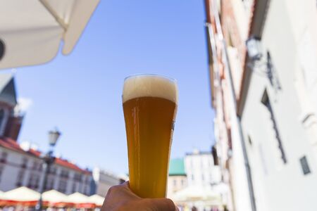 Male hand holding a glass of unfiltered beer