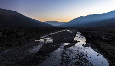 Mountain river bed at sunset day