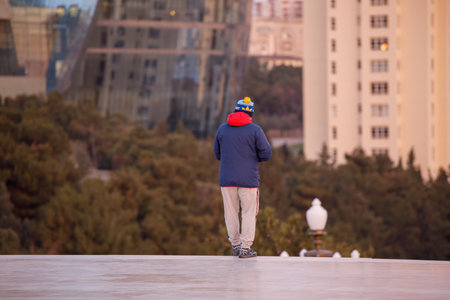 Baku, Azerbaijan, - December 26, 2019: Man in sportswear on the background of buildingsのeditorial素材