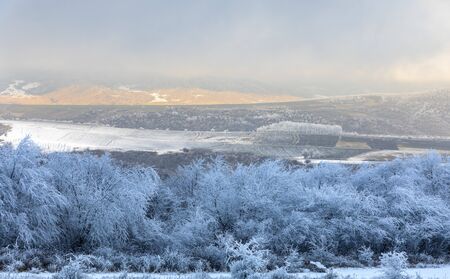Trees covered with hoarfrost and ice in the mountains at sunset day