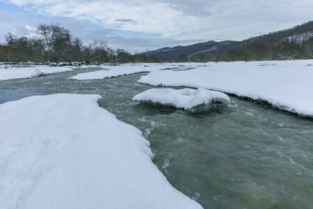 River passing through a mountain gorge in winterの写真素材