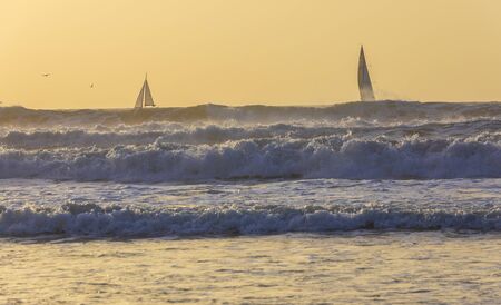 Sailboats sailing in a stormy seaの写真素材