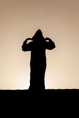 Silhouette of a girl in a tunic against the backdrop of the setting sunの写真素材