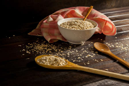 Two wooden spoons with a bowl of oatmealの写真素材