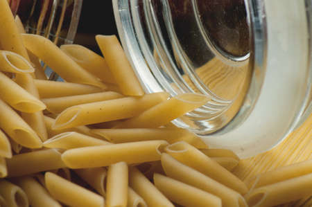 Raw pasta macaroni pour out of jarの写真素材