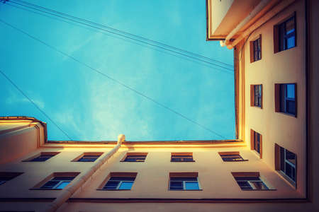 Beautiful geometry of the city. The bottom geometrical view of the city yard with the blue sky. 