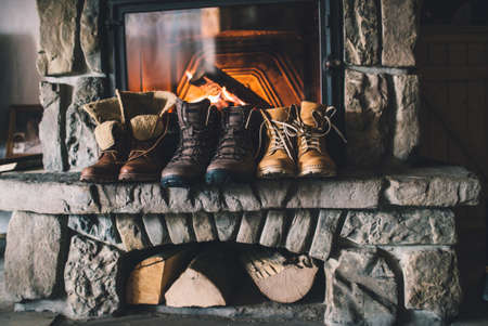 Winter boots in front of a fireplace.の写真素材