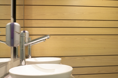 Washbasin and wooden bathroom wall reflected in the mirrorの写真素材