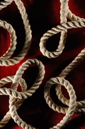 Artistic abstract pattern of rope twists on dark red backgroundの写真素材