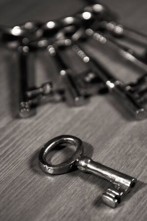 Bunch of old antique brass keys on a table black and whiteの写真素材