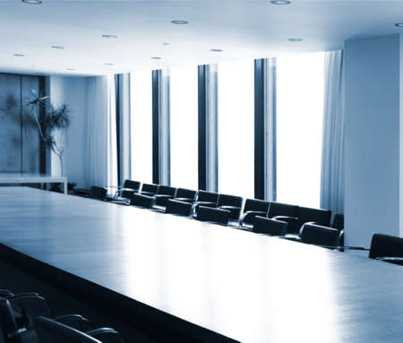 Boardroom conference room table brightly lit in blue colorsの写真素材