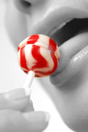 Closeup of woman licking lollipop candyの写真素材
